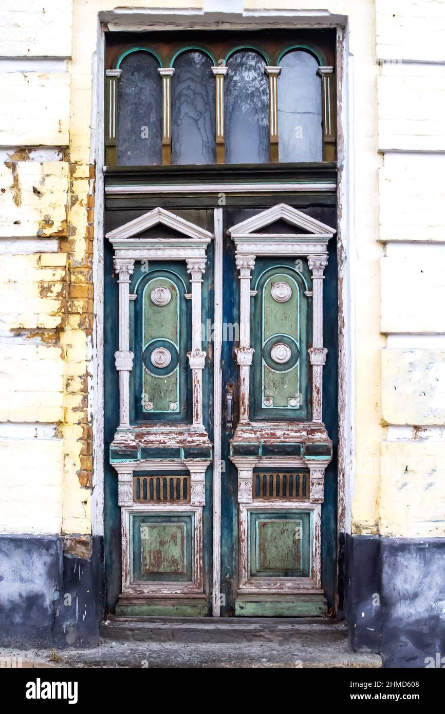 Old wooden painted door. Elegant old double-leaf door in an abandoned building in Kiev, Ukraine. An old wooden doorway in the wall of an old stone hou Stock Photo