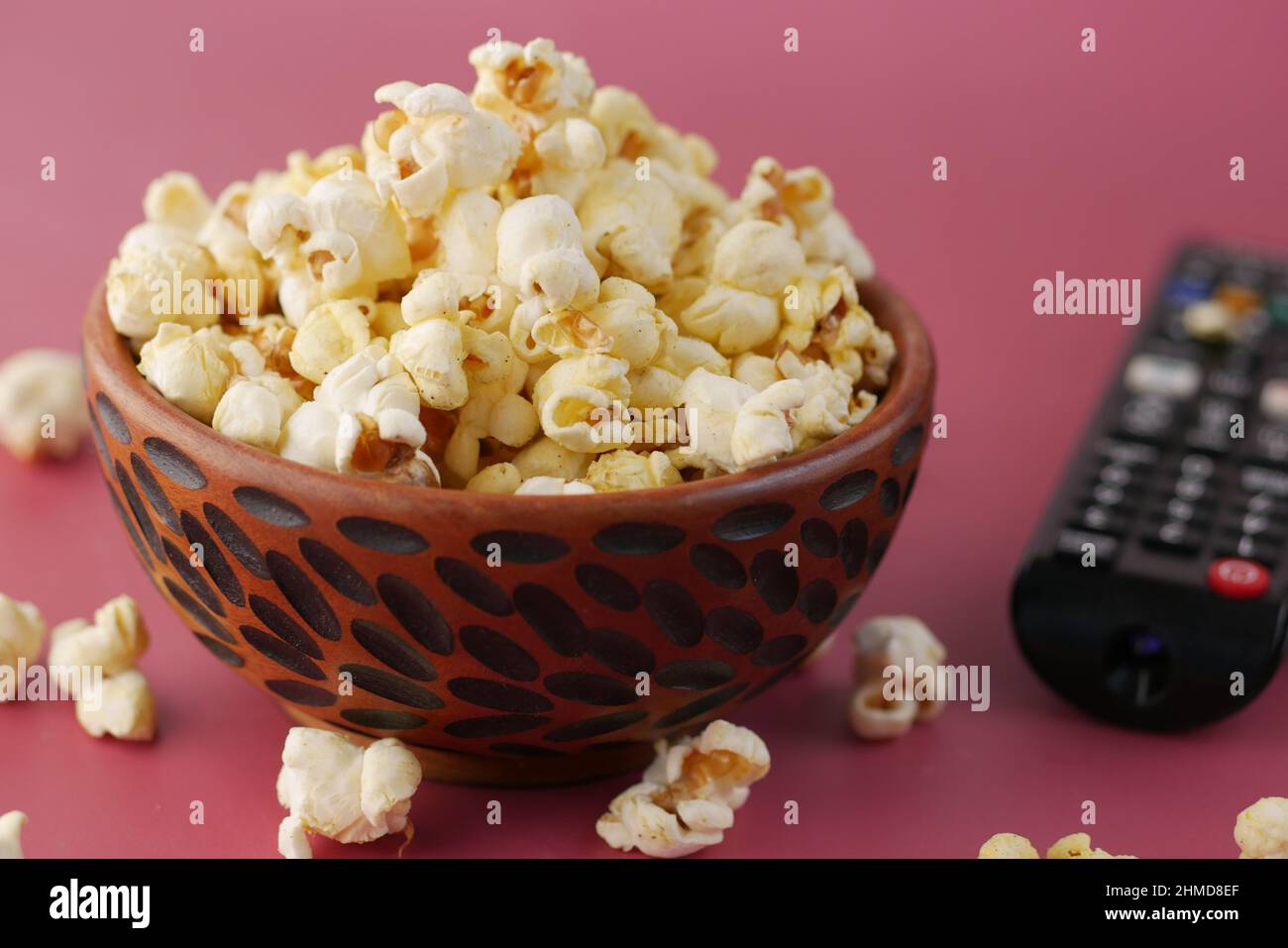 popcorn and Tv remote on red background  Stock Photo