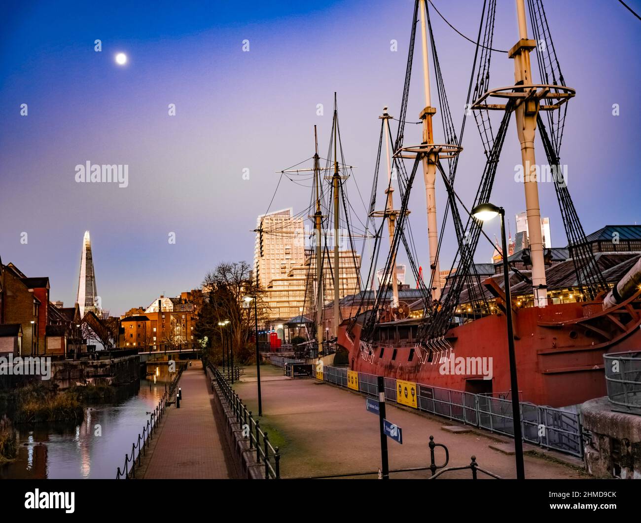 Tabacco Dock dusk, pirate ship, with full moon and Shard. Stock Photo