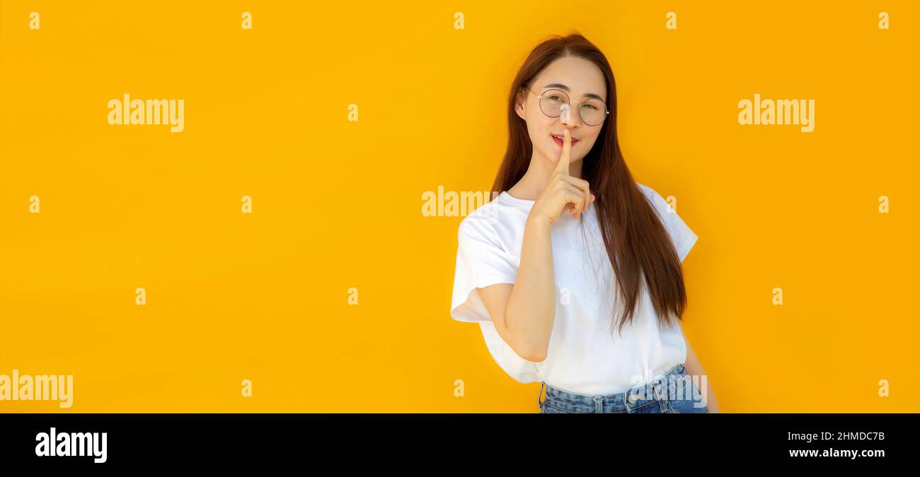 asian woman model in casual white shirt and jeans on yellow isolated background. Stock Photo