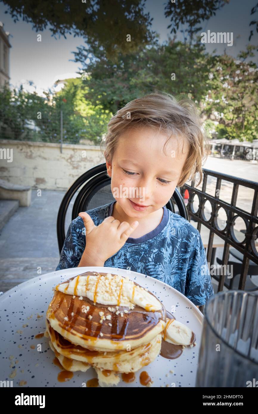 Portrait of boy eating pancake at outdoor cafe Stock Photo Alamy