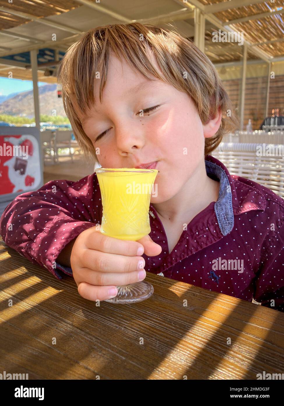 Boy having fun drinking fresh juice at restaurant Stock Photo