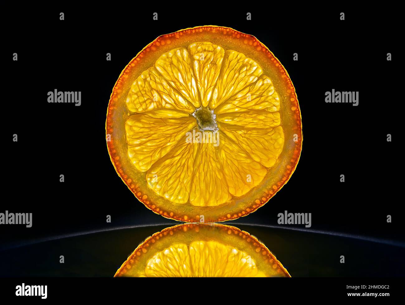 Slice of a orange isolated in dark black bacnground with reflection Stock Photo