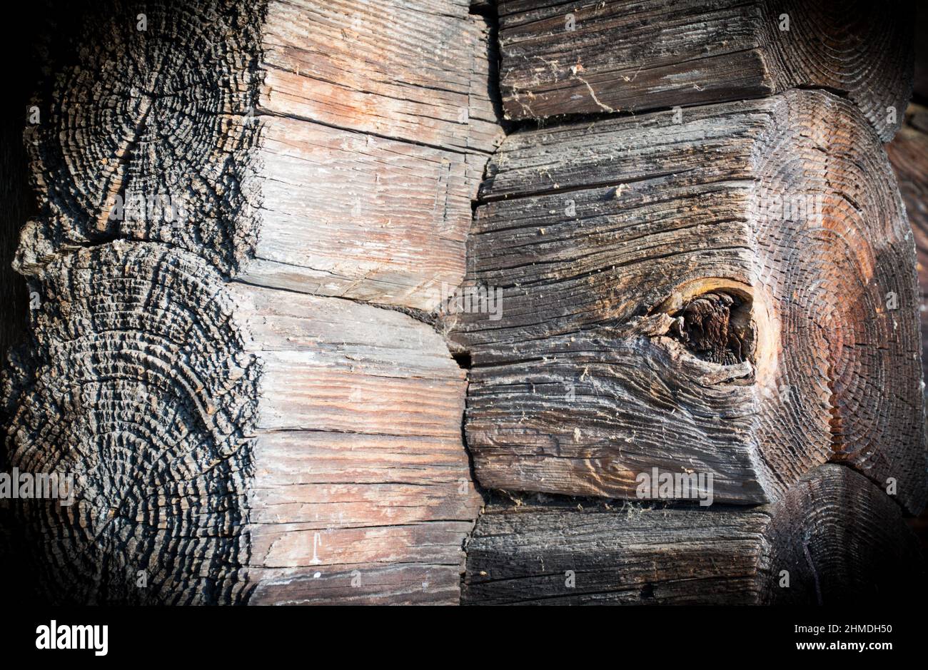 Fragment of the corner of the wall of an old abandoned log house. Background image Stock Photo