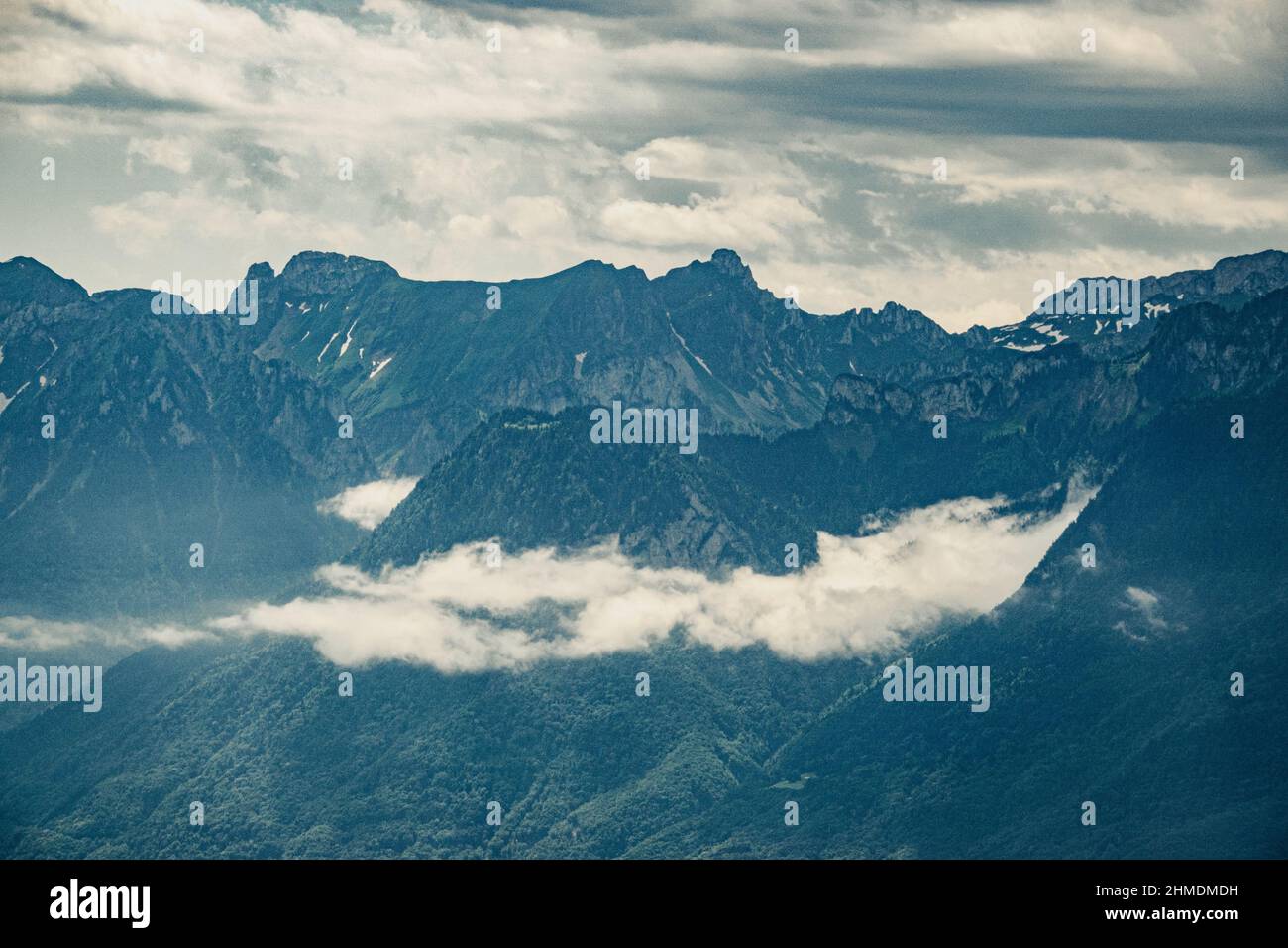 Beautiful view of mountains covered with clouds on sunny day Stock Photo