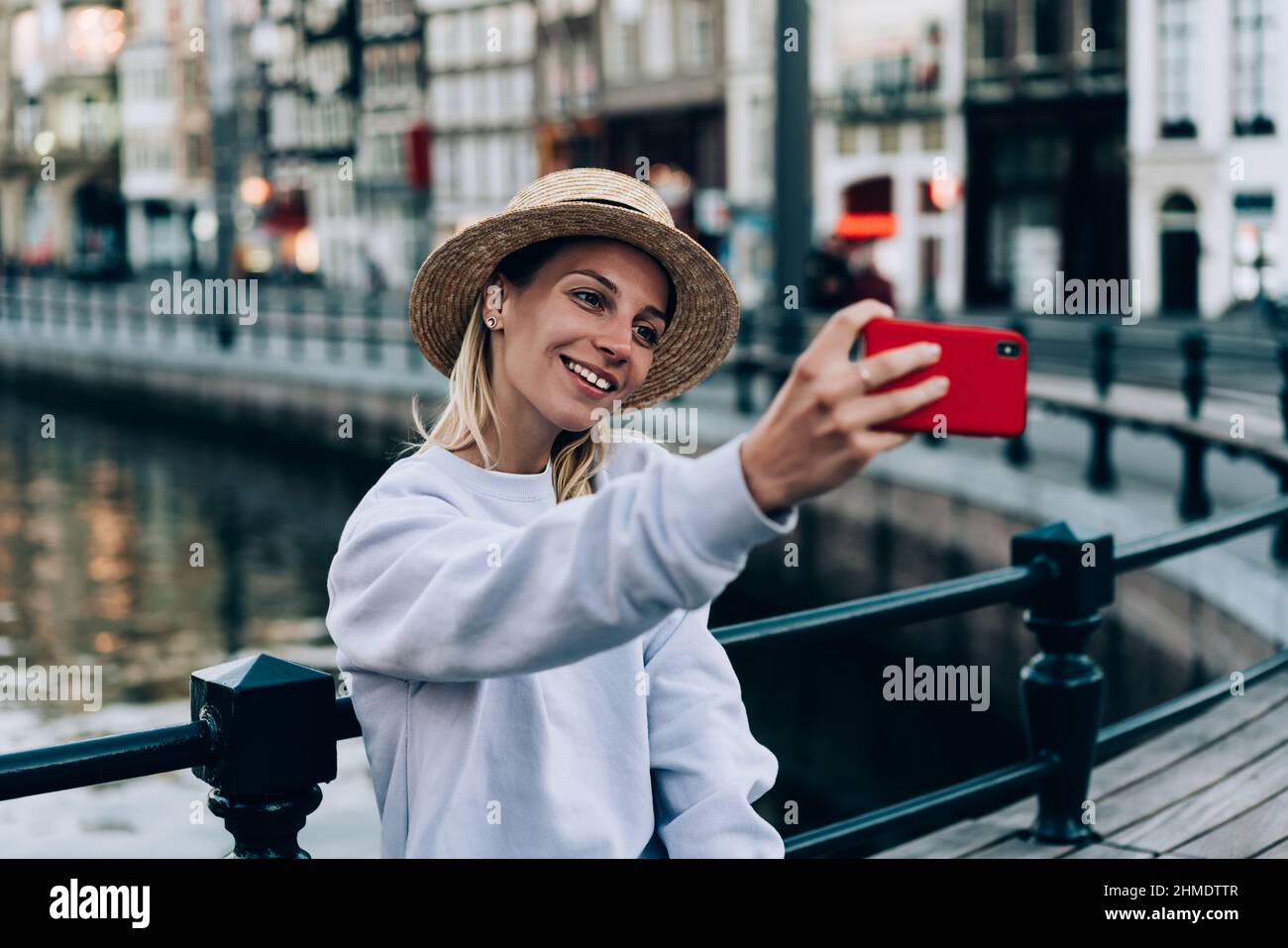 Happy woman photographing on smartphone during tour Stock Photo