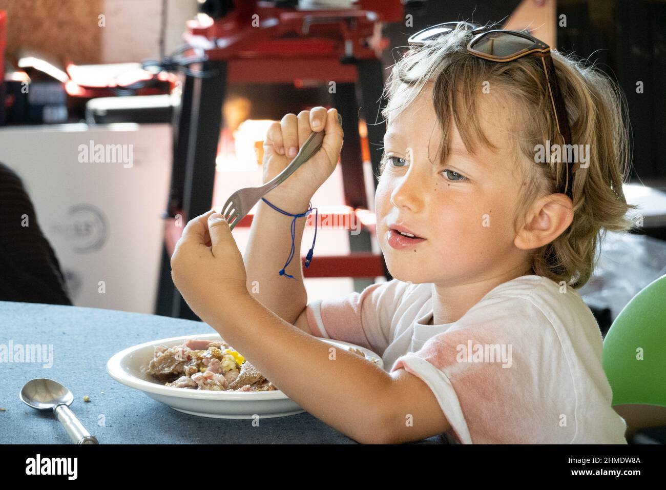 Little boy eating food using fork at home, Brittany, France Stock Photo