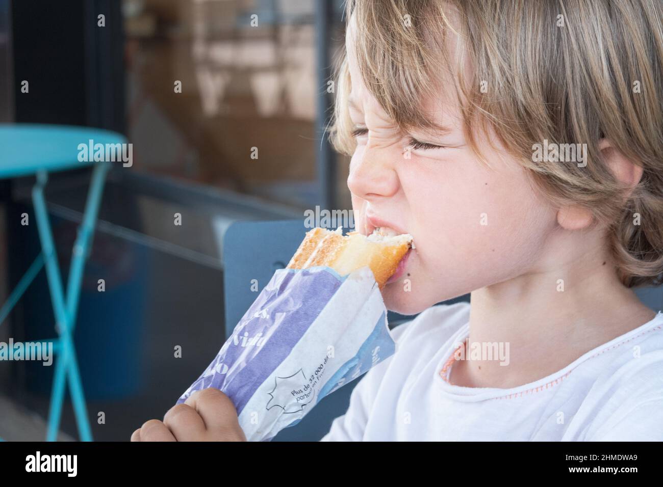 Close up of boy biting wrapped street food snack, Brittany, France Stock Photo