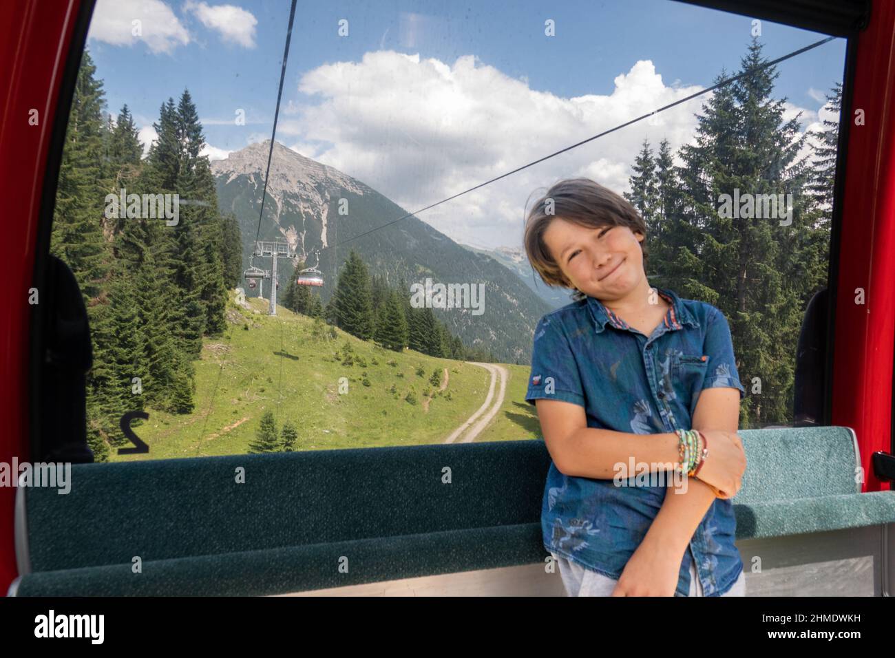 Portrait of boy leaning on overhead cable car against forest, Austria Stock Photo