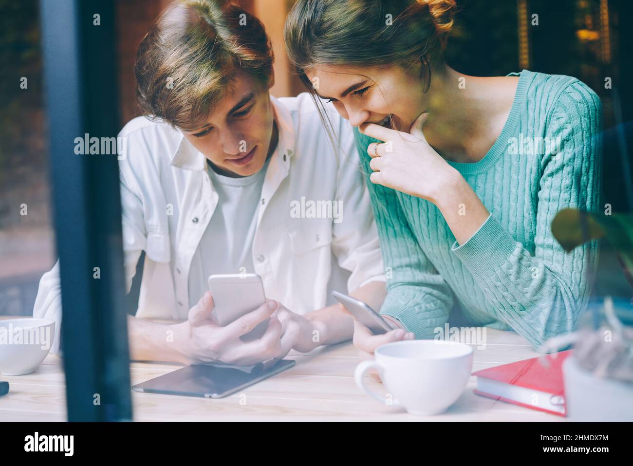 Positive friends using smartphones in cafe Stock Photo