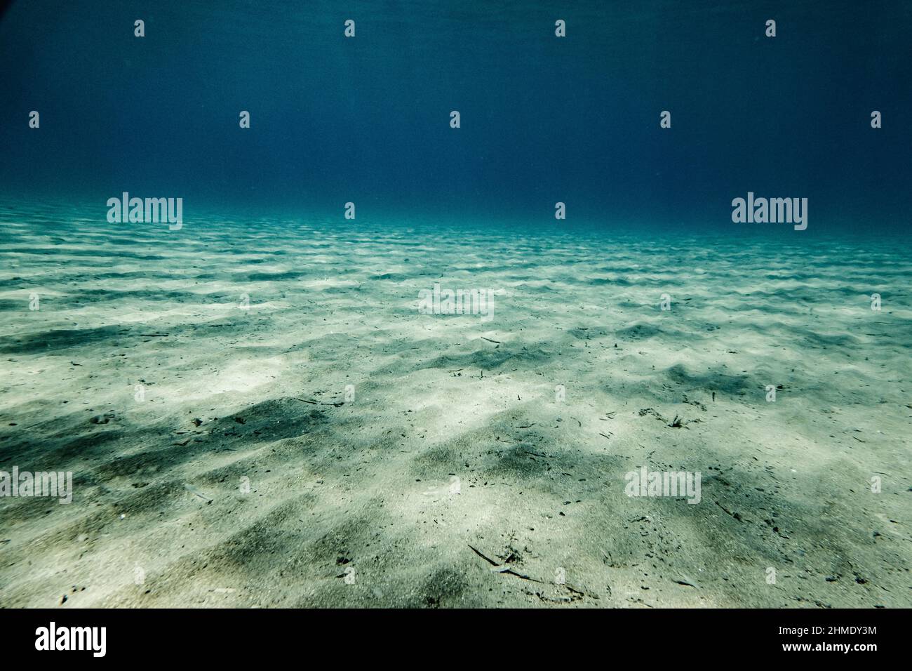 Sunlight on rippled sand on bottom of ocean floor Stock Photo