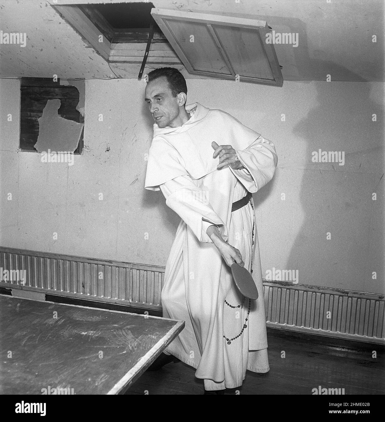 Monk plyaing table tennis. A monk in a white robe is playing table tennis. Sweden 1951 Kristoffersson ref BE28-6 Stock Photo