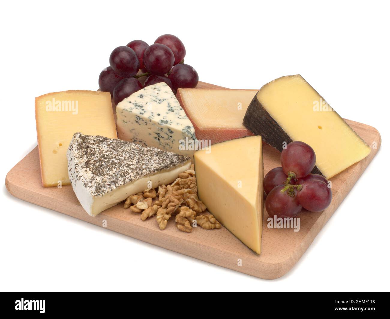 A wooden board with cheese, nuts, grapes Stock Photo