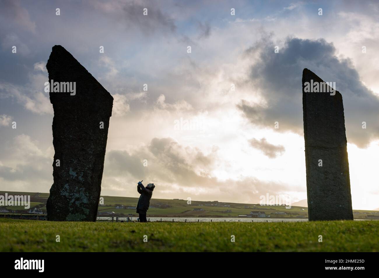 Stenness, Orkney, UK. 9th Feb, 2022. A lone visitor to the Stones of Stenness - a neolithic stone circle - in Orkney, Scotland, braves the ice cold wind in the late afternoon. Credit: Peter Lopeman/Alamy Live News Stock Photo