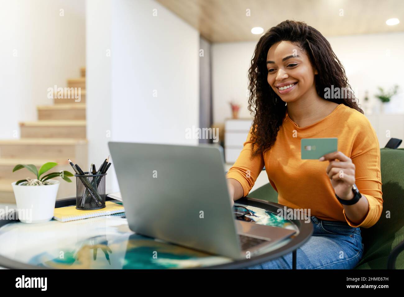 Happy woman holding debit credit card, using pc Stock Photo - Alamy
