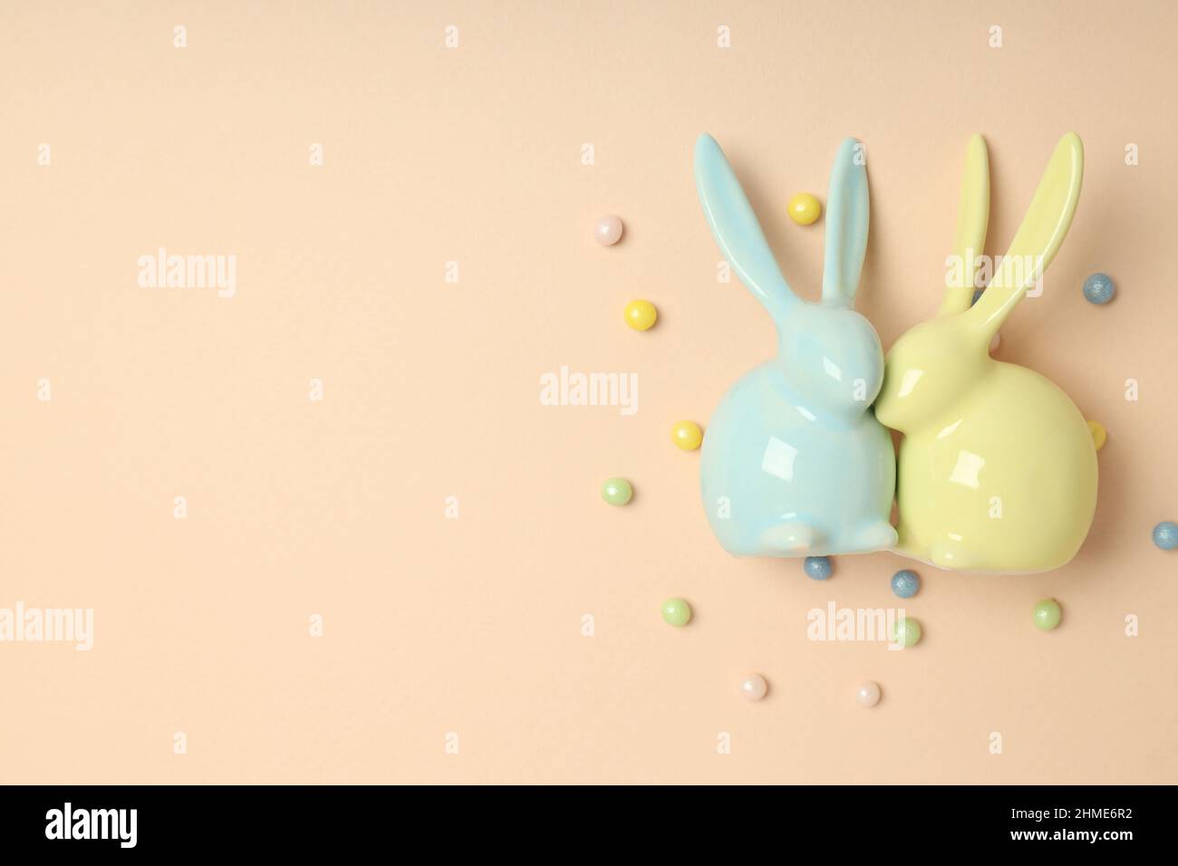 Easter bunnies on beige background, space for text Stock Photo