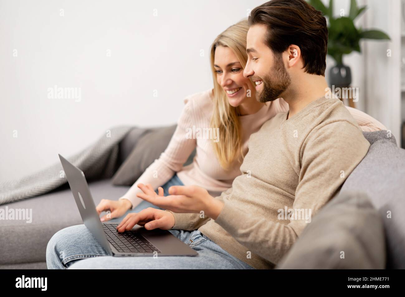 Loving young caucasian couple sitting together at home spending time and  happy to be together. Happy