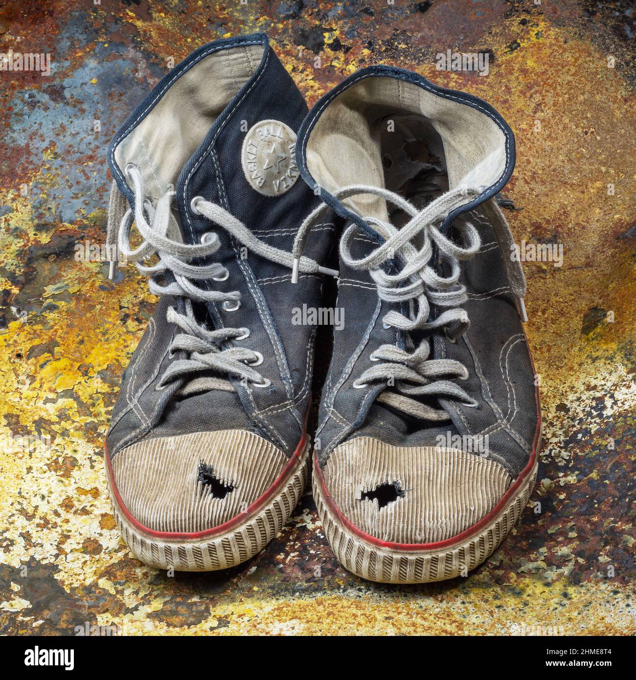 Pair of old and worn tennis shoes on rusty backgraound Stock Photo - Alamy