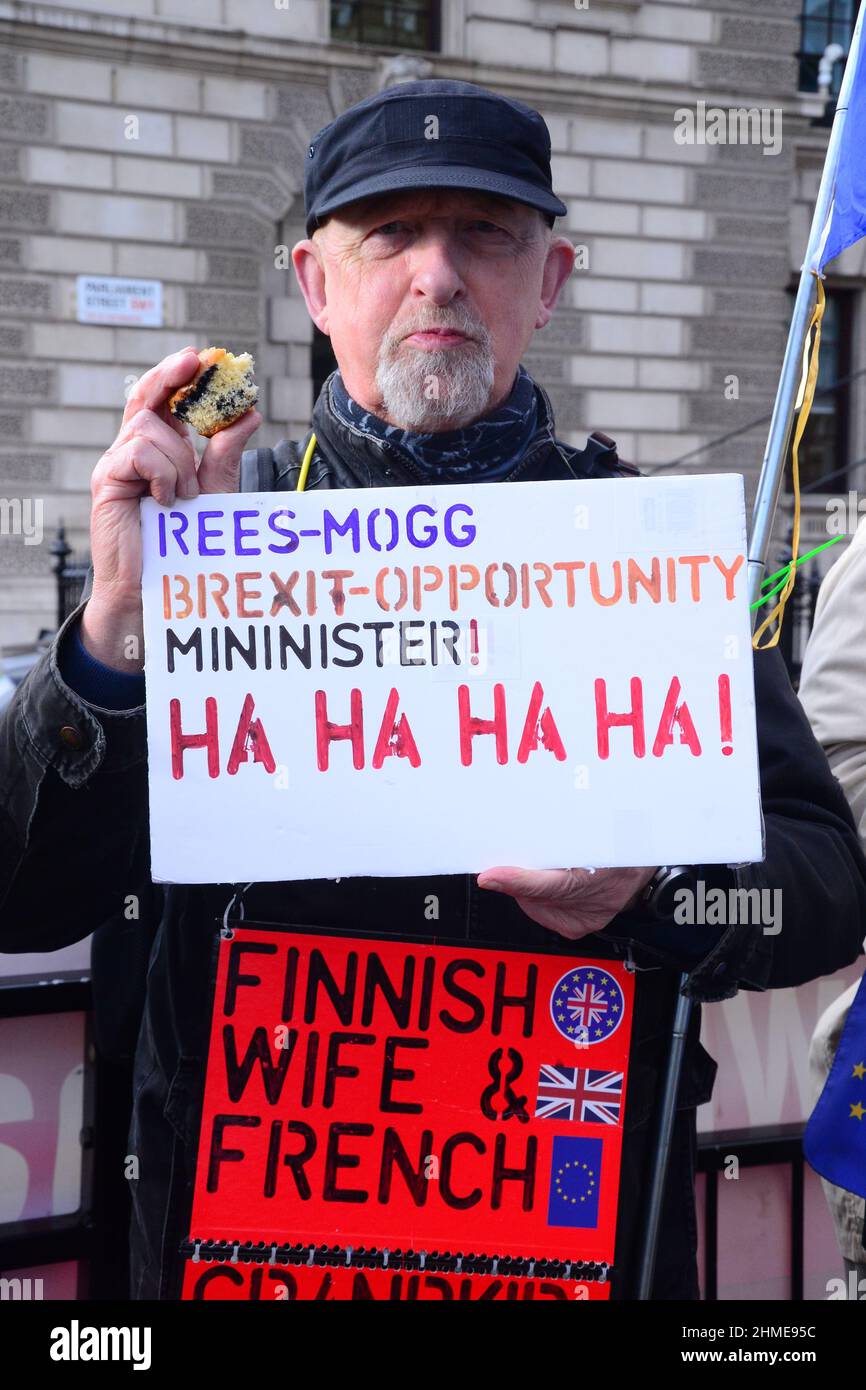 London, UK, 9th February, 2022. An anti brexit protester holds a placard making fun of Rees Mogg's new position as Minister for Brexit Opportunities as part of a protest across the road from the House of Commons. Stock Photo