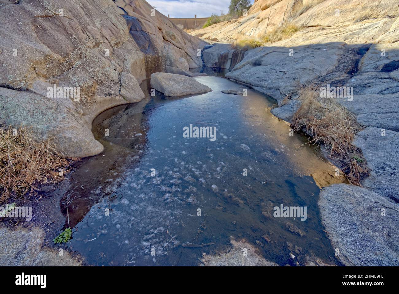 A large pool of frozen water downstream from the Willow Lake Dam Spillway in Prescott Arizona. Stock Photo