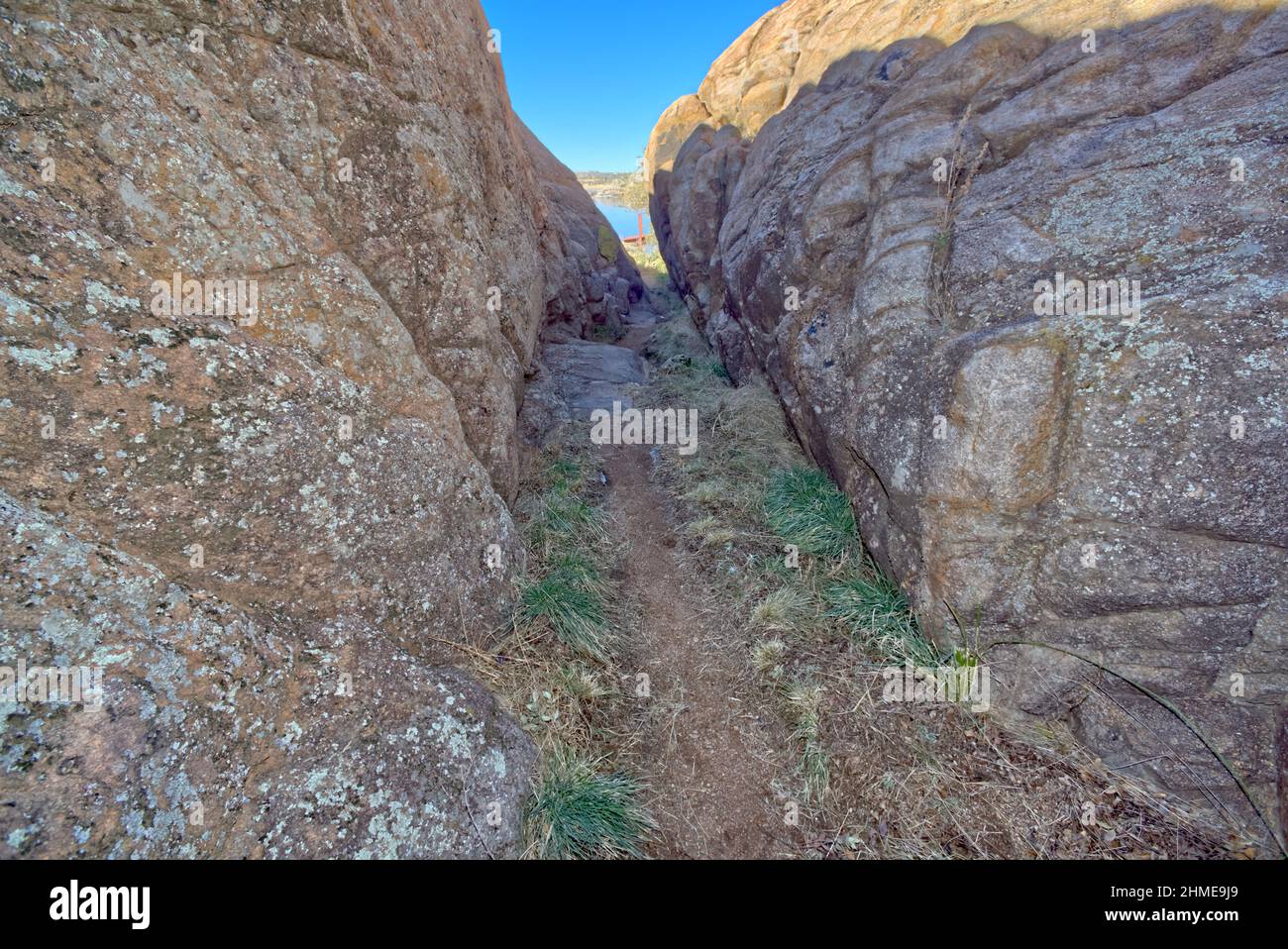 A narrow path between walls of Granite that marks the beginning of the Red Bridge Trail at Willow Lake in Prescott Arizona. Stock Photo