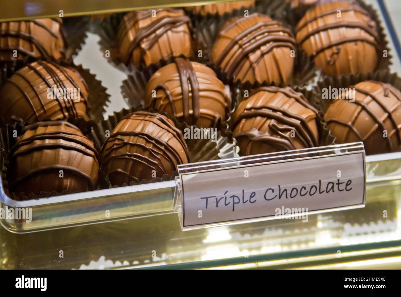 Close up display of rich, hand dipped triple chocolate candies on sale at a confectioners Stock Photo