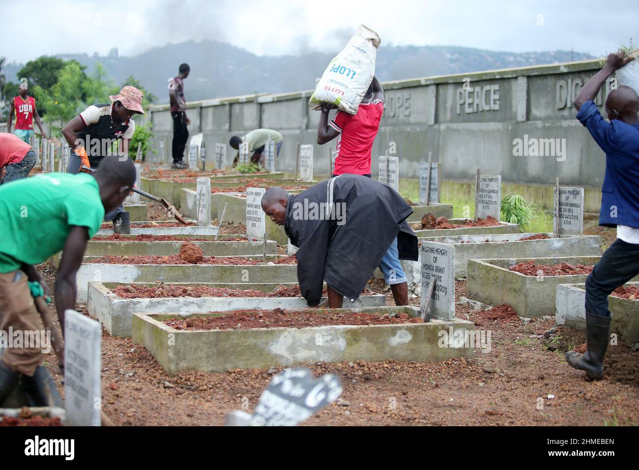 A cemetery is tended to in Sierra Leone's capital Freetown, where victims of the 2015 Ebola crisis were buried. Stock Photo