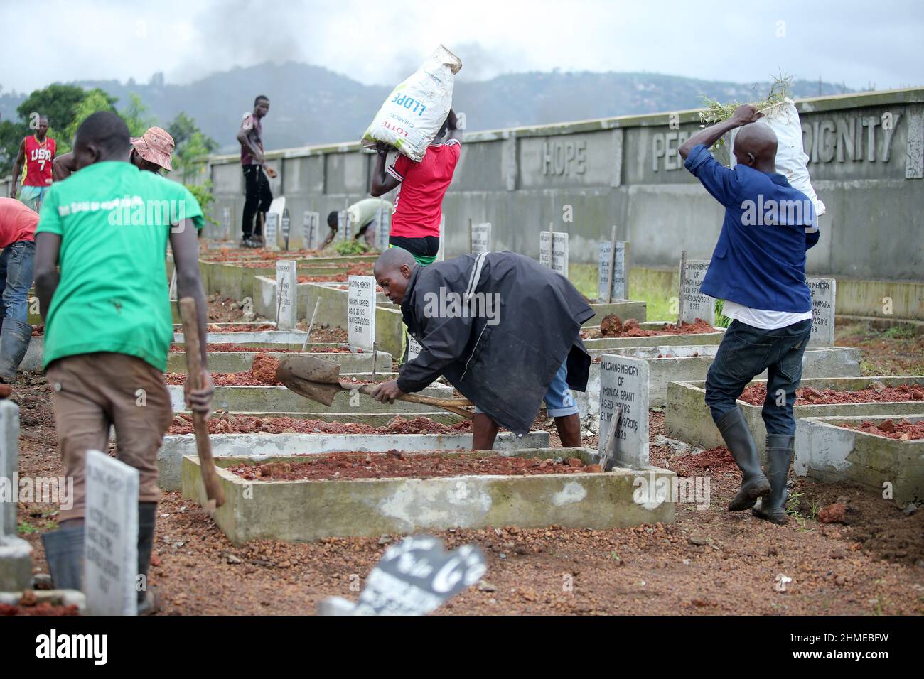 A cemetery is tended to in Sierra Leone's capital Freetown, where victims of the 2015 Ebola crisis were buried. Stock Photo