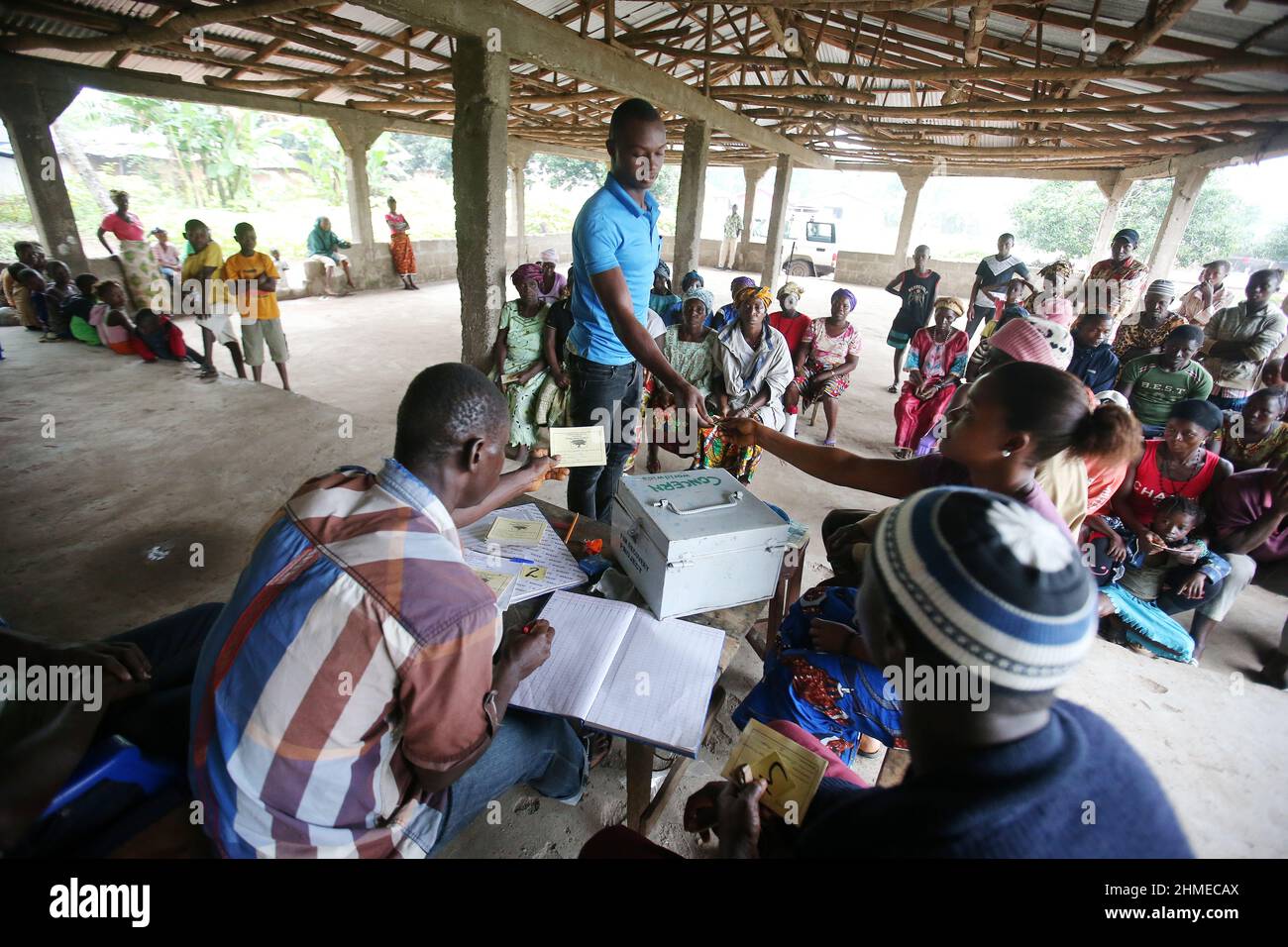 People gather at a community bank in Sierra Leone to deposit and save their money. Stock Photo