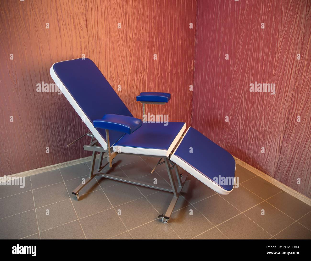 Blue medical chair for cosmetology standing in the corner of a room