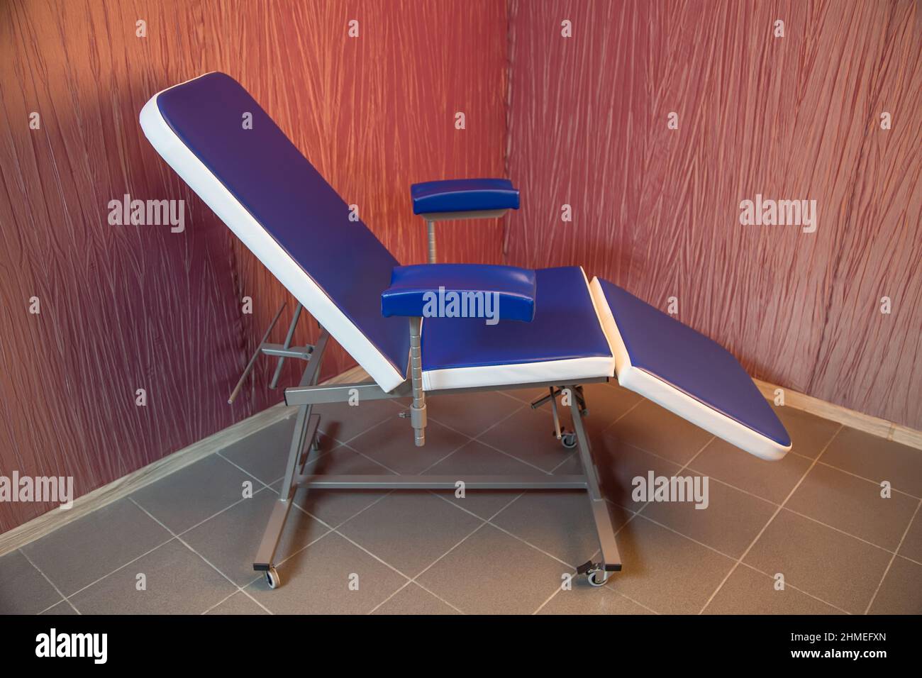 Blue medical chair for cosmetology standing in the corner of a room
