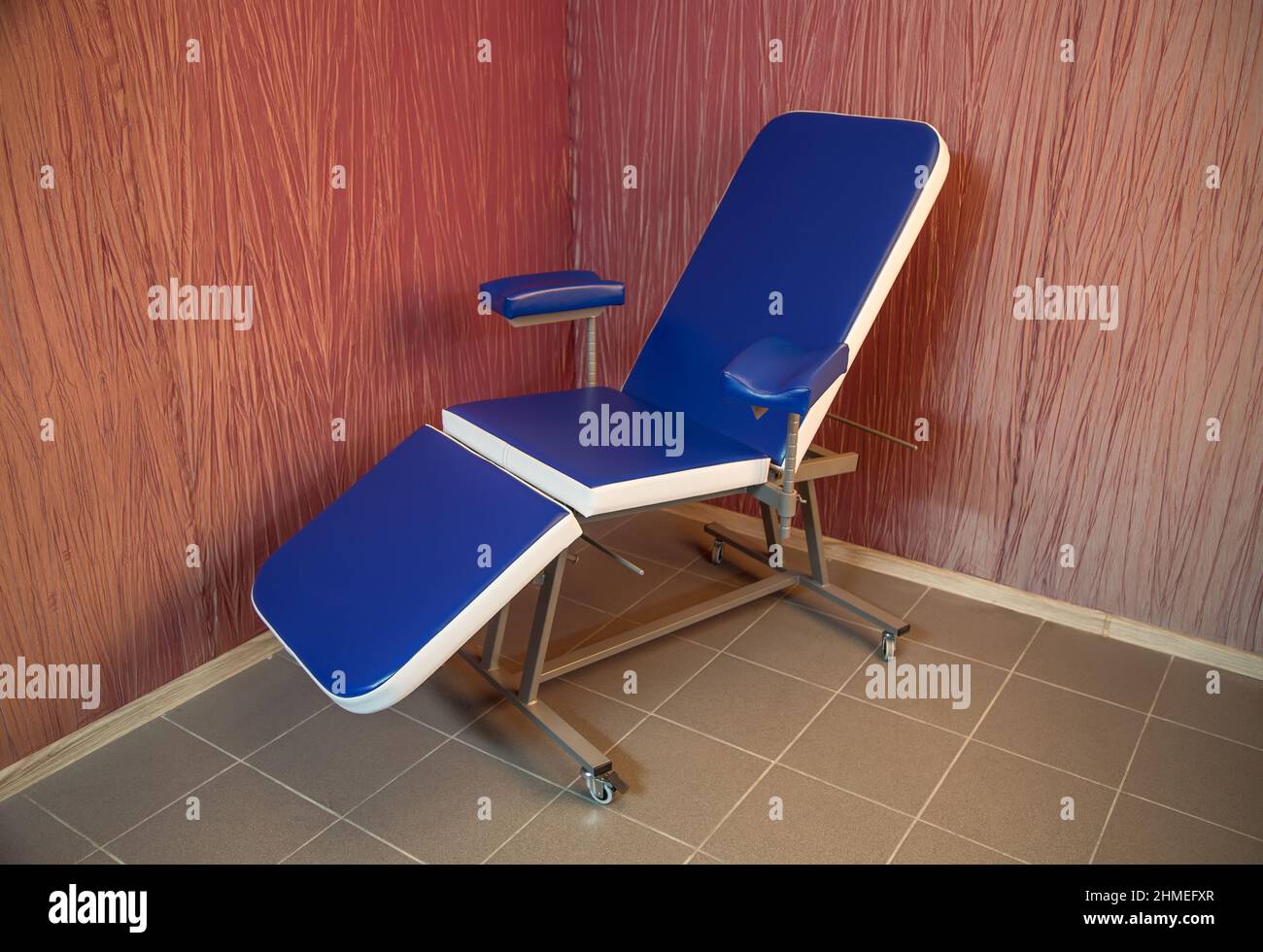 Blue medical chair for cosmetology standing in the corner of a room