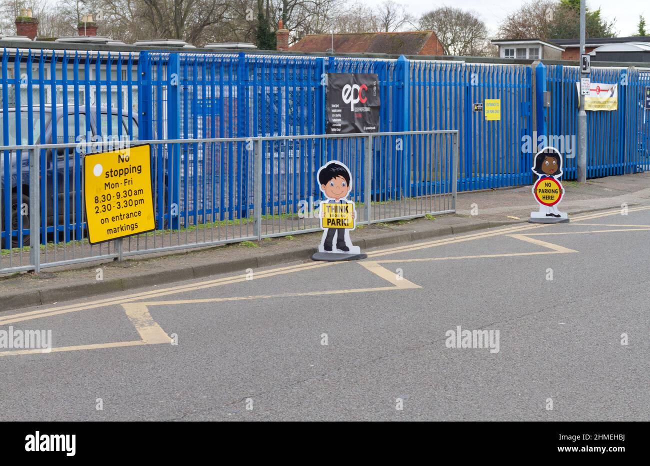 Signs outside a school warning people not to park on zig zag lines and