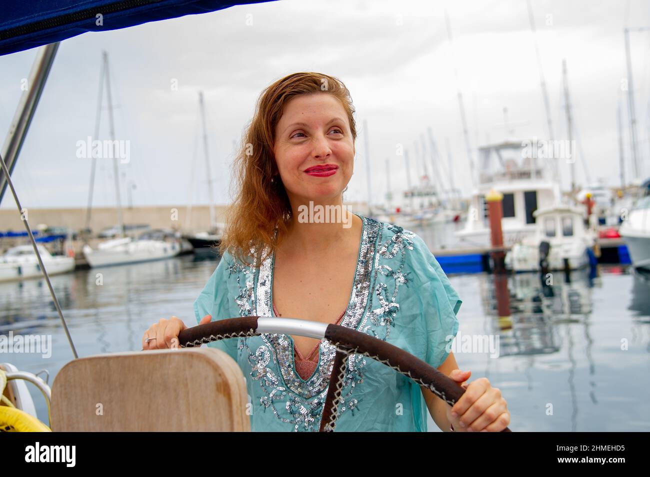 Attractive mature woman posing in the harbor and on the beach in