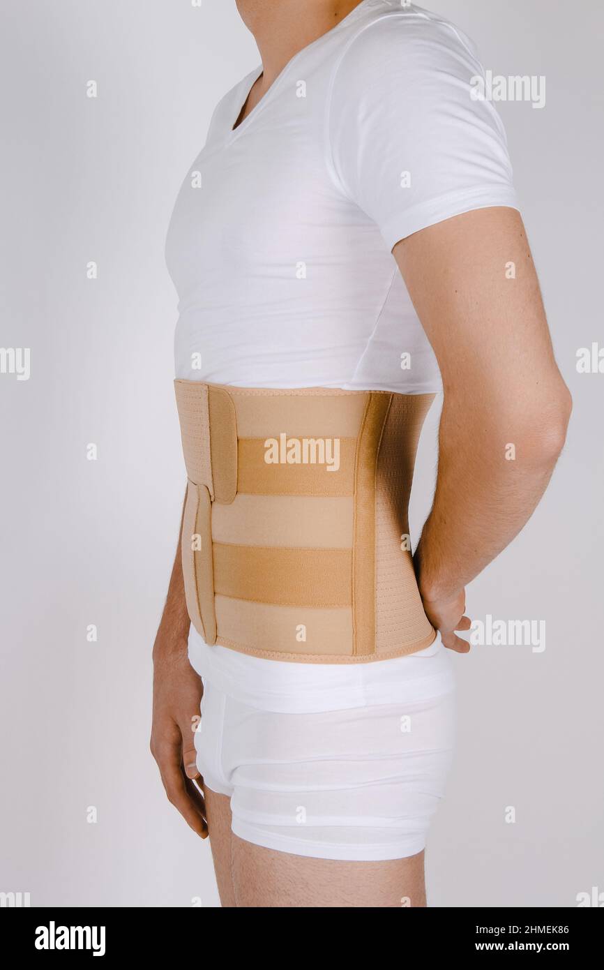 Orthopedic lumbar corset on the human body. Back brace, waist support belt for back. Posture Corrector For Back Clavicle Spine. Post-operative Hernia Stock Photo