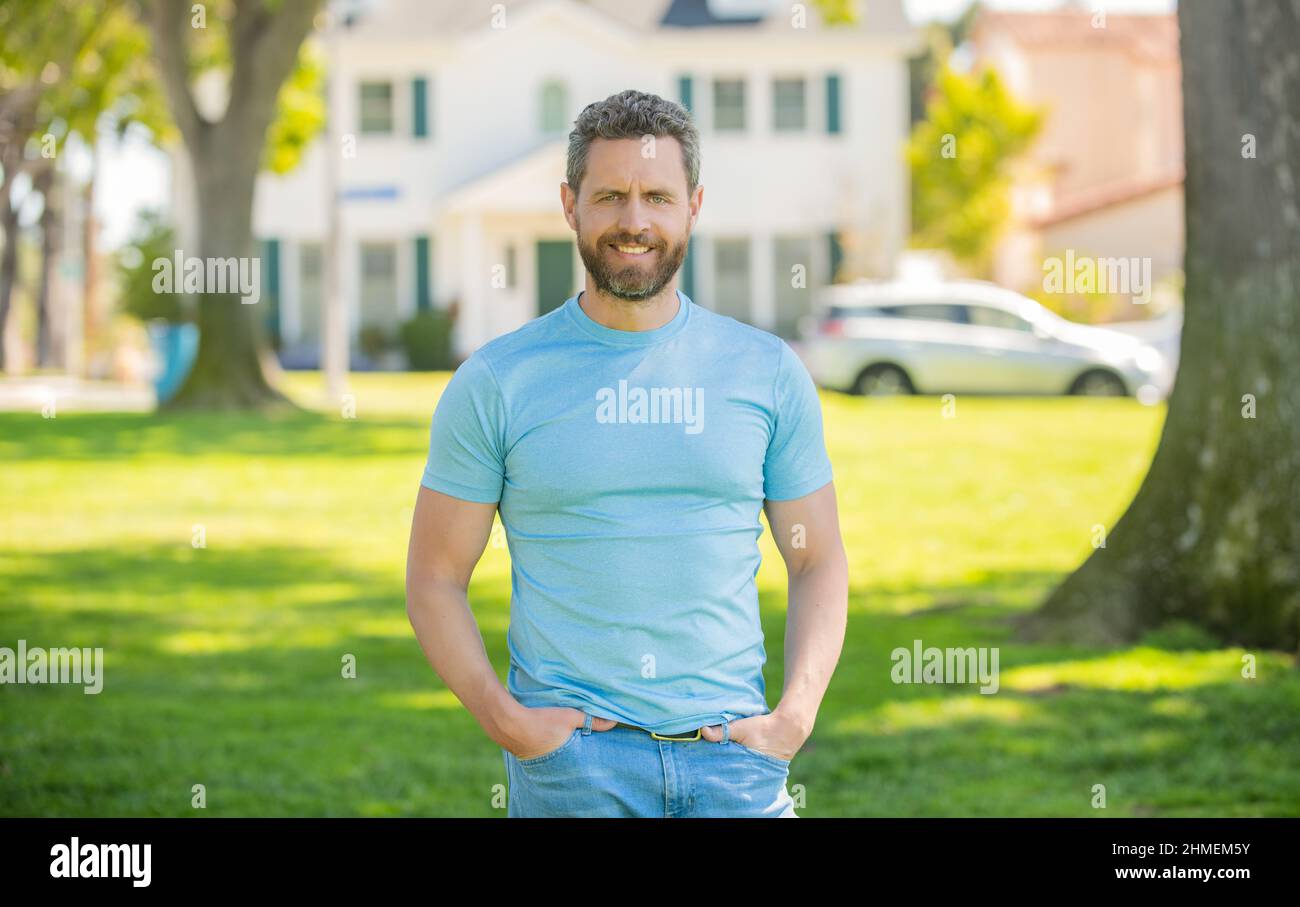 happy bearded man standing on house background, for sale Stock Photo