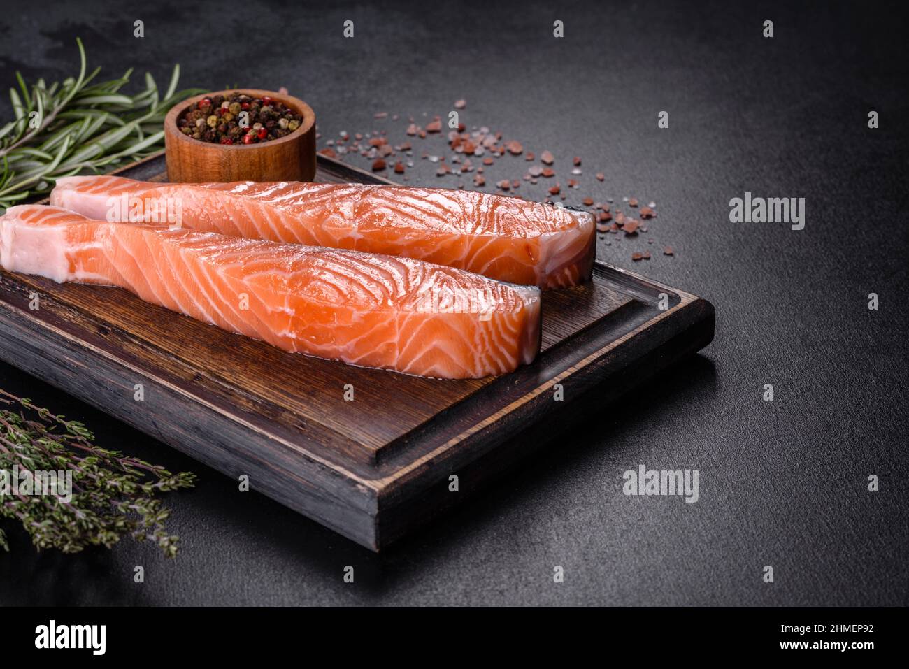 Salmon. Fresh raw salmon fish fillet with cooking ingredients and herbs on black background