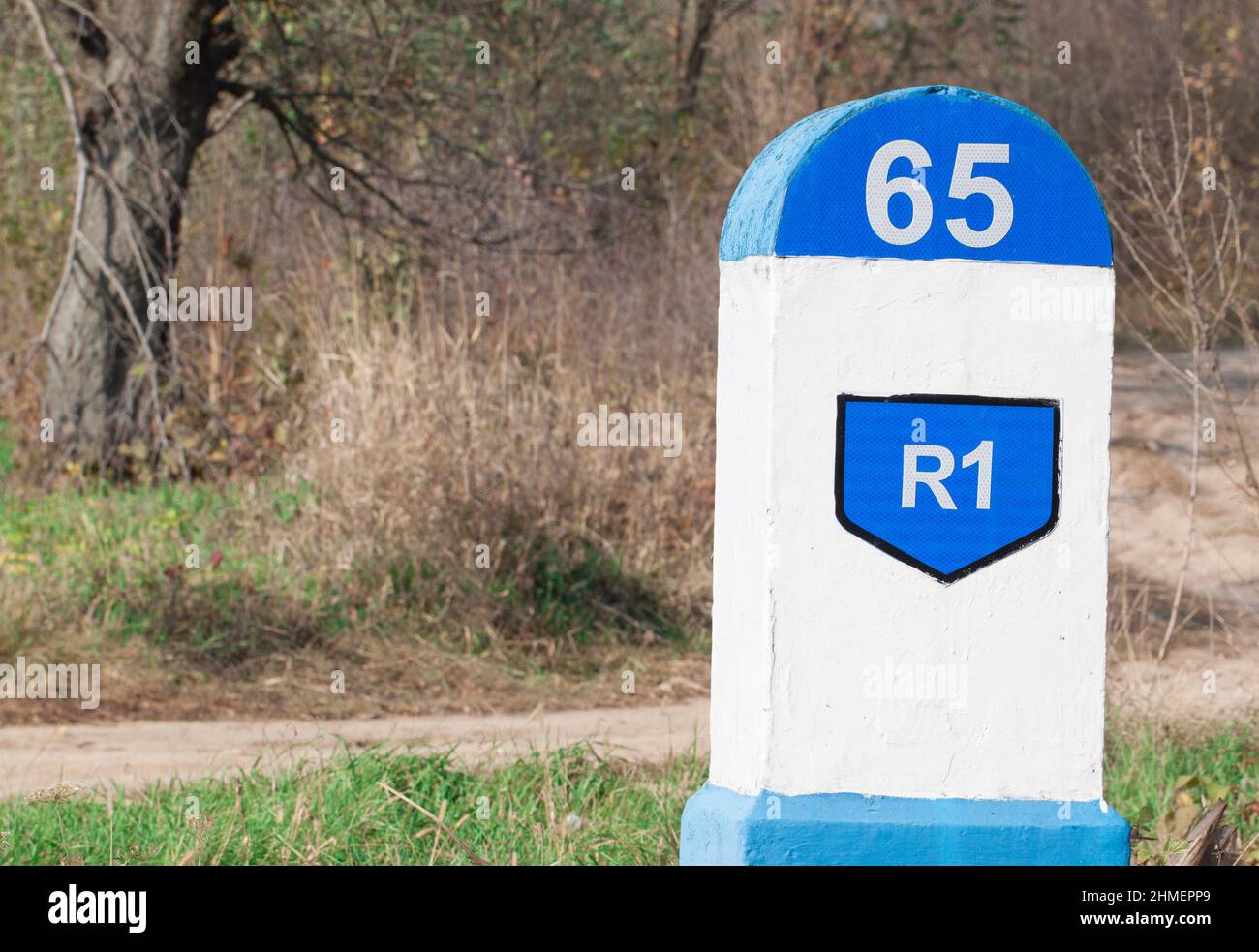 Distance sign indicator on the road with forest background Stock Photo