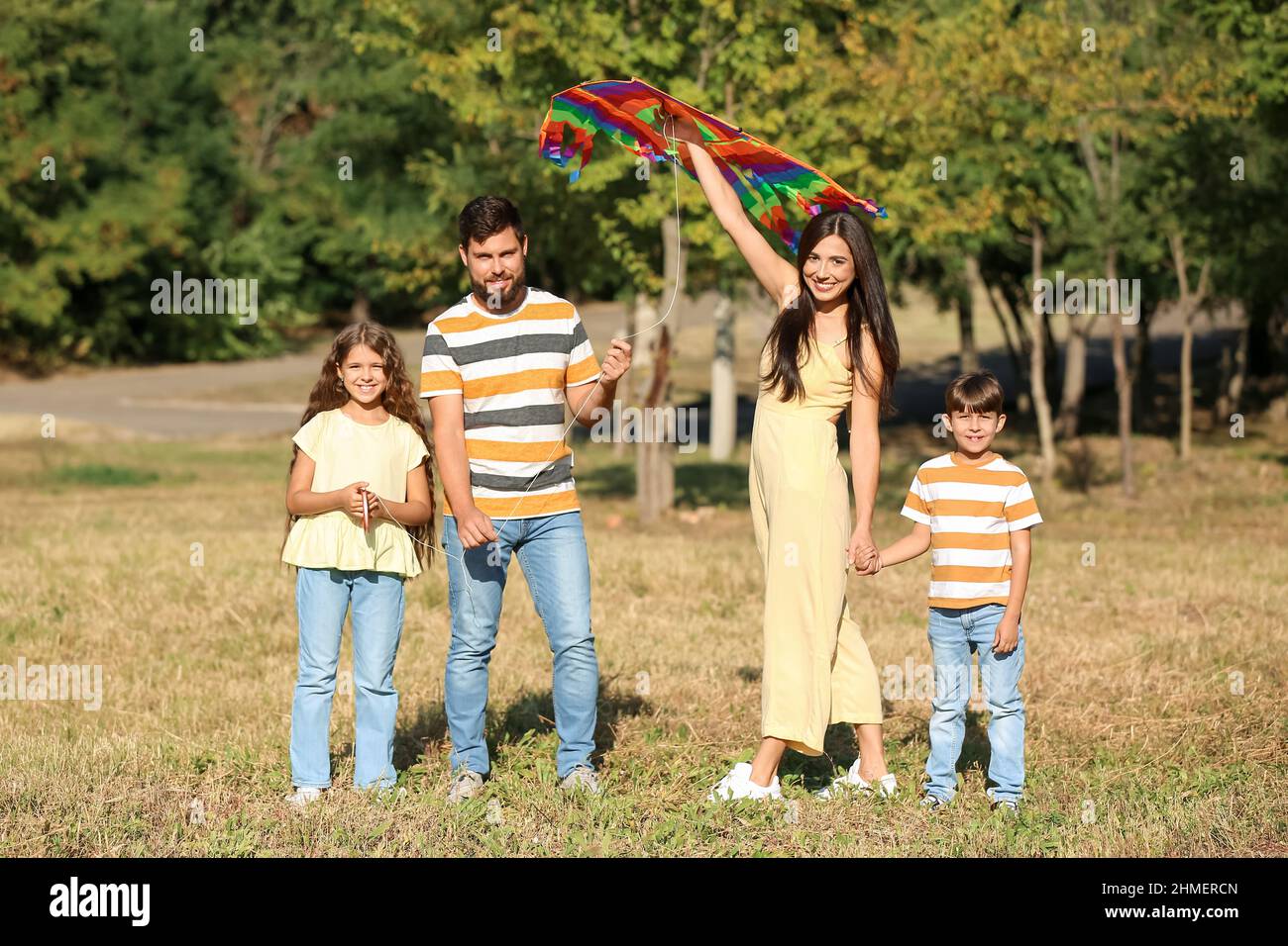Happy couple with little children and kite outdoors Stock Photo
