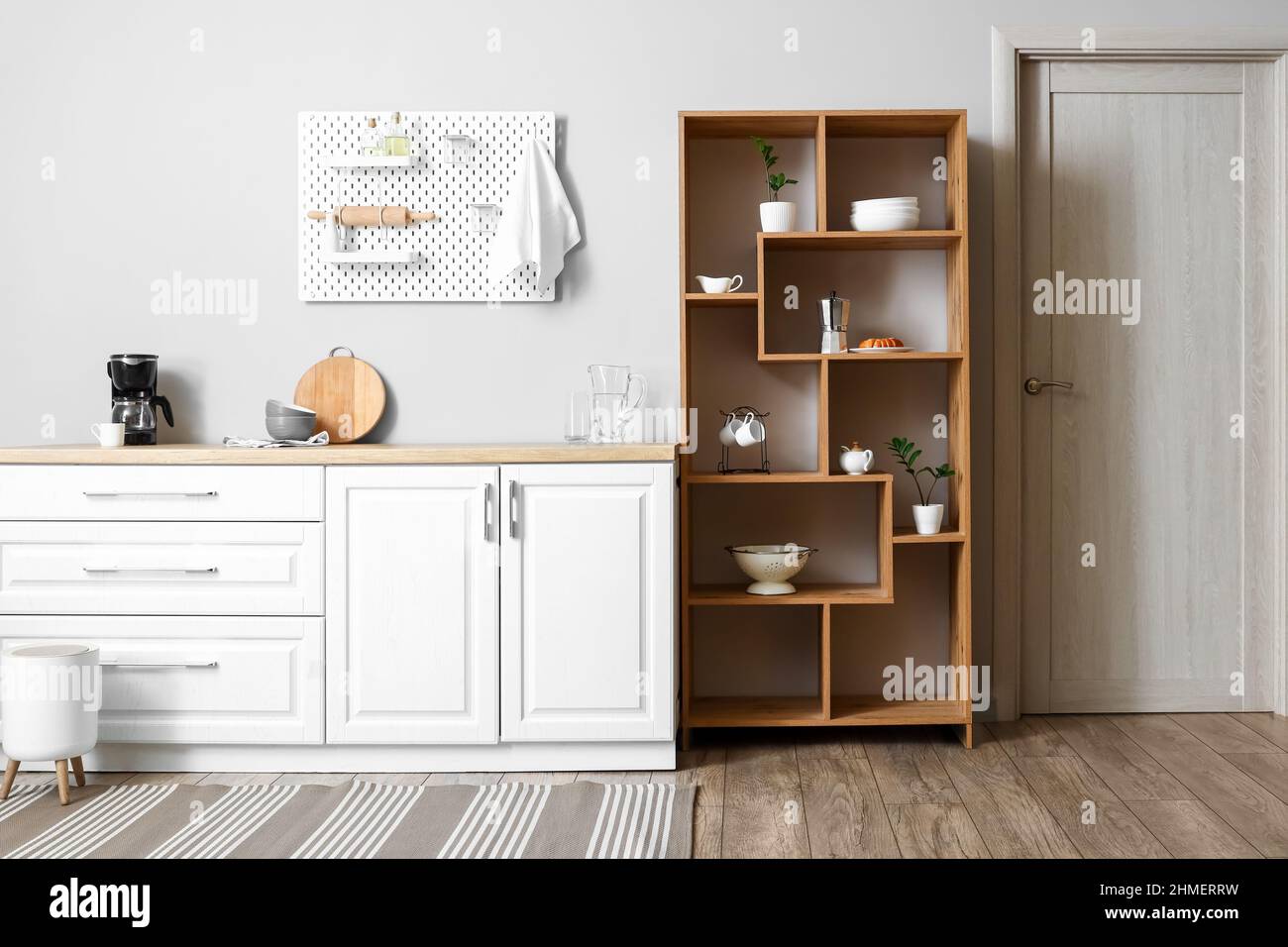 Interior of light kitchen with wooden shelving unit and pegboard Stock ...
