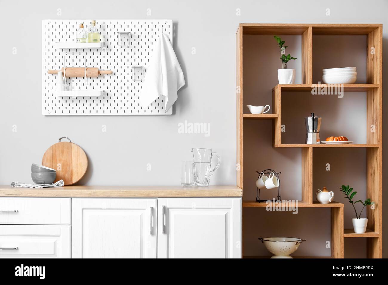Interior of light kitchen with wooden shelving unit and pegboard Stock ...