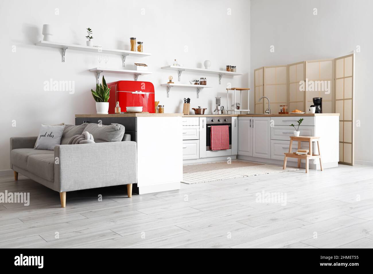 Interior of light kitchen with white counters and sofa Stock Photo - Alamy