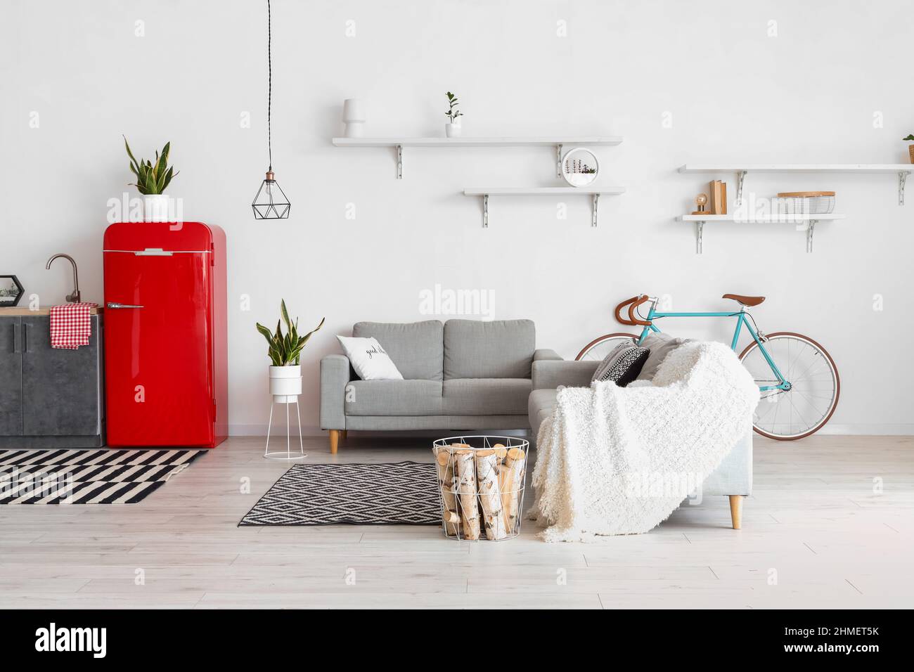 Interior of modern kitchen with counters, sofas and red fridge Stock