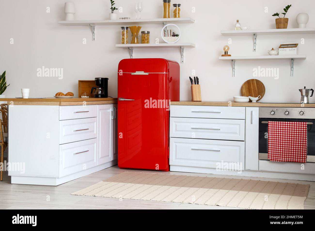 Interior of light kitchen with white counters and red fridge Stock ...