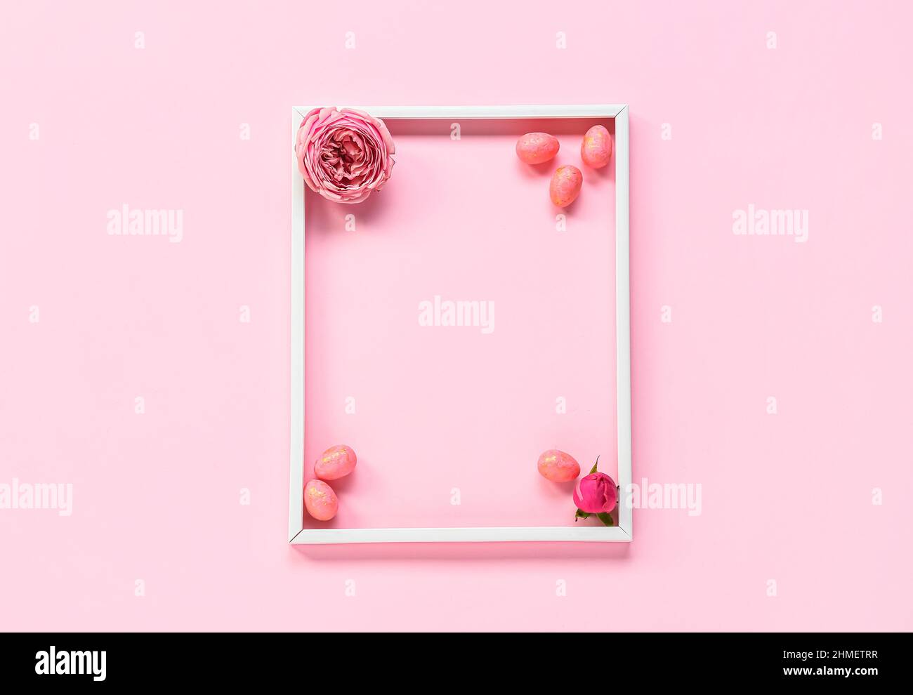 Beautiful composition with frame, Easter eggs and flowers on pink ...