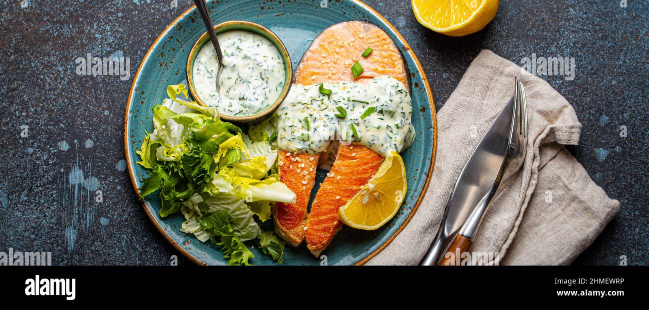 Healthy food meal cooked grilled salmon steaks with dill sauce and salad leafs on plate Stock Photo