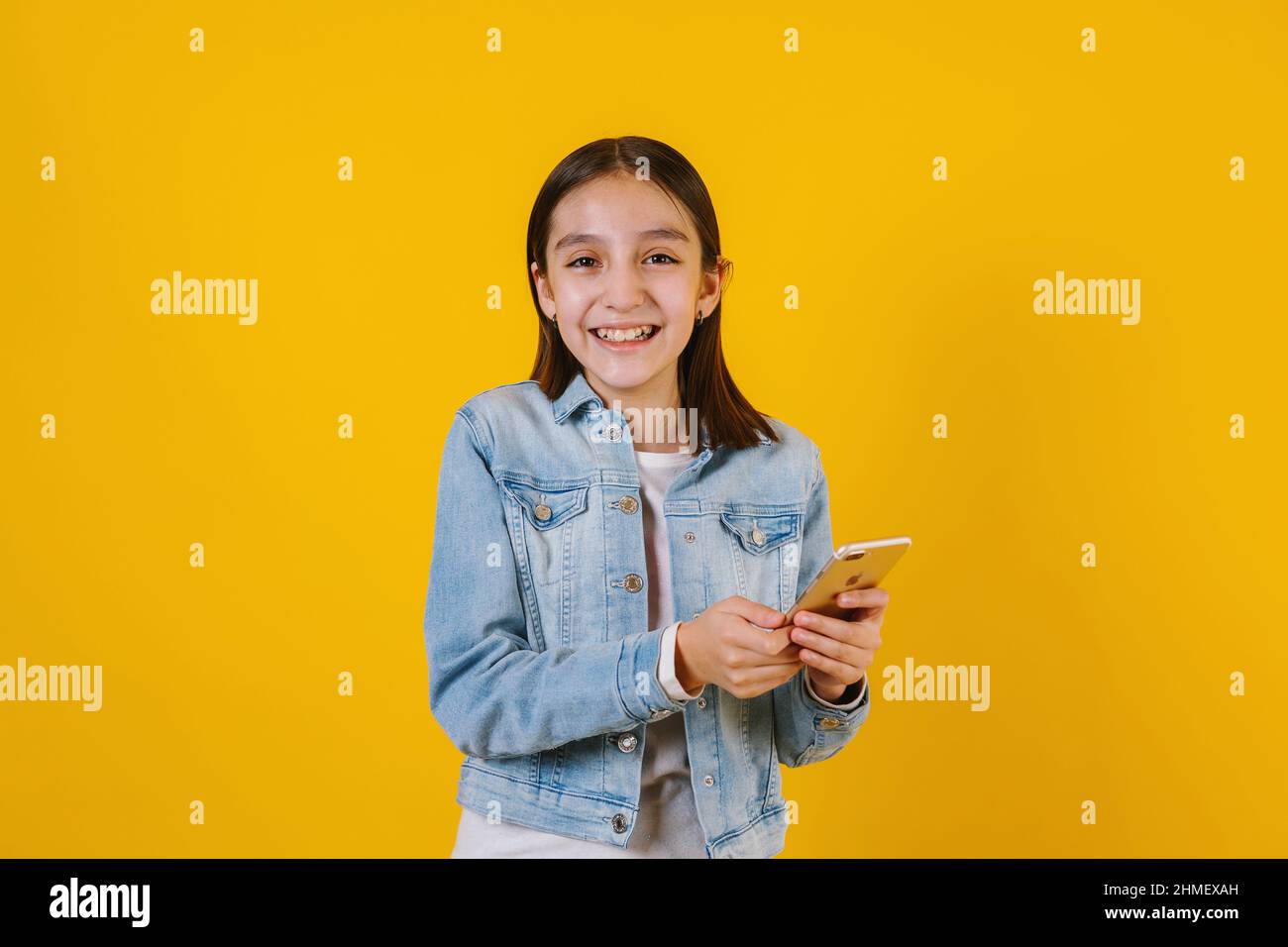 Portrait of latin child girl on yellow background in Mexico Latin America Stock Photo