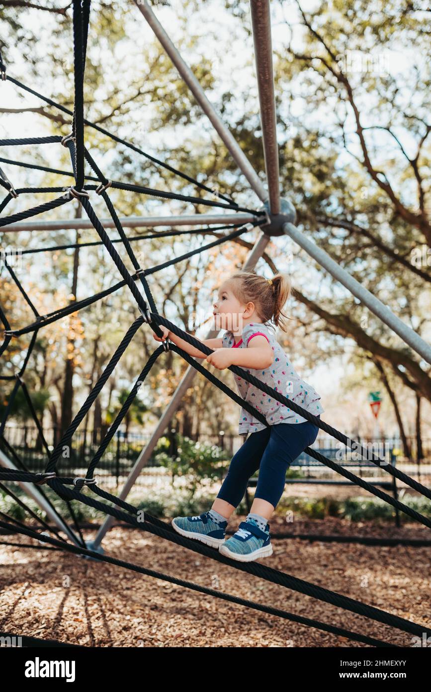 Child at playground. Little girl on a playground climbing net tower