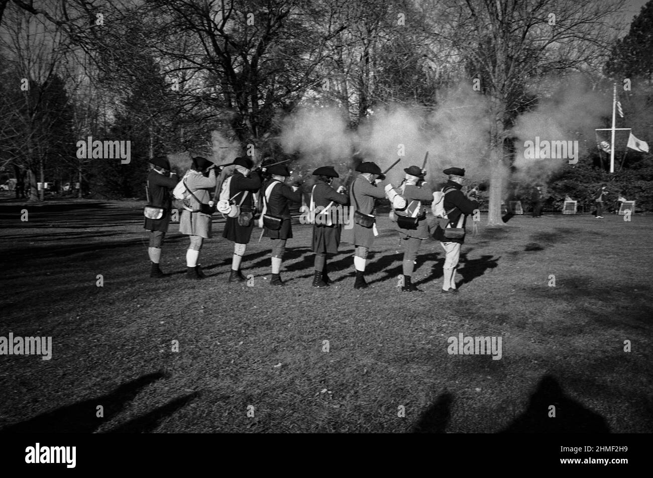 Reenactment characters dressed as Minutemen fire muskets on an autumn day at the Tea Burning Ceremony. Lexington, Massachusetts Stock Photo