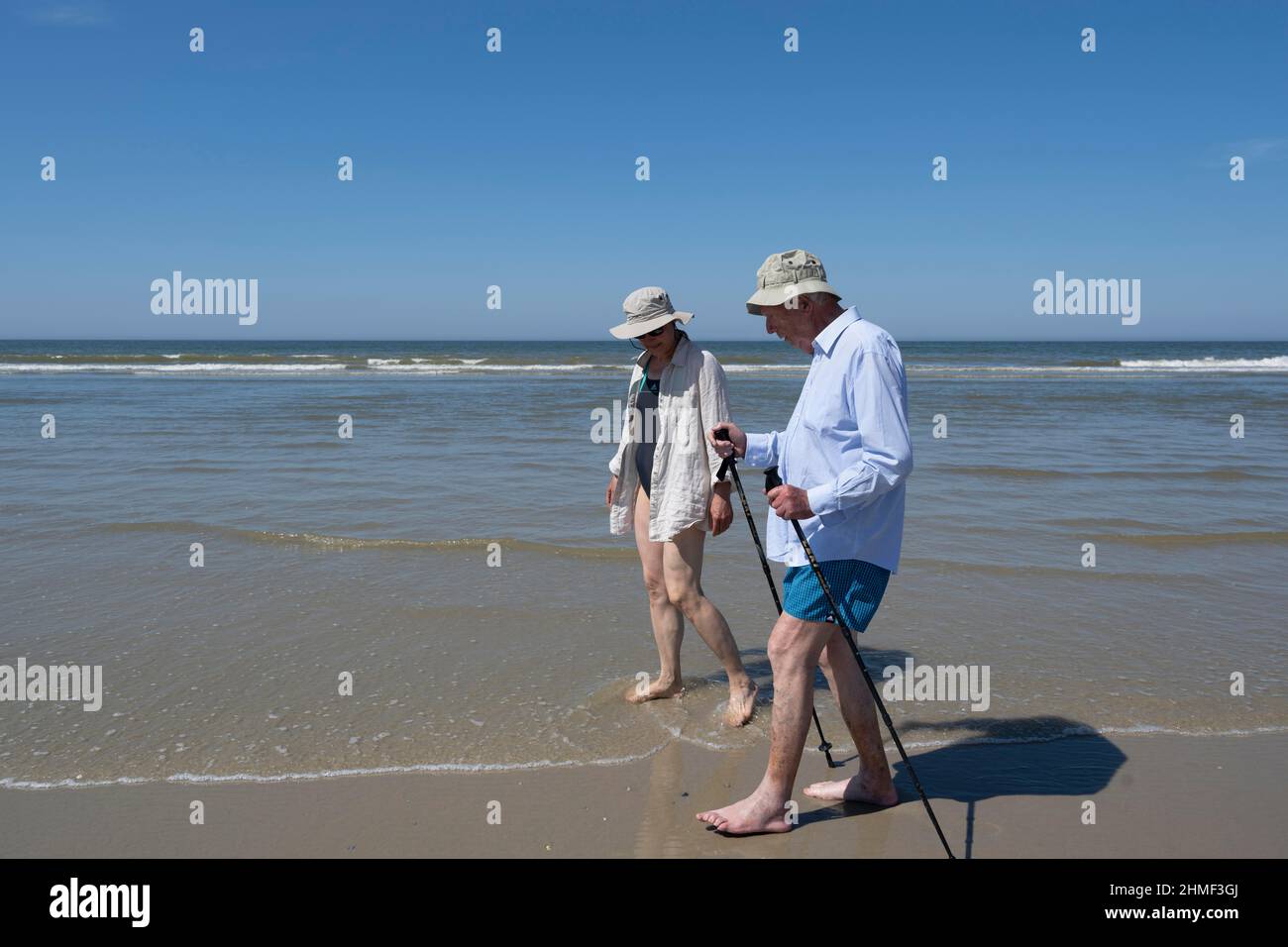 Elderly man accompanied by woman walking on the beach, Juist Island, North Sea, East Frisia, Lower Saxony, Germany Stock Photo
